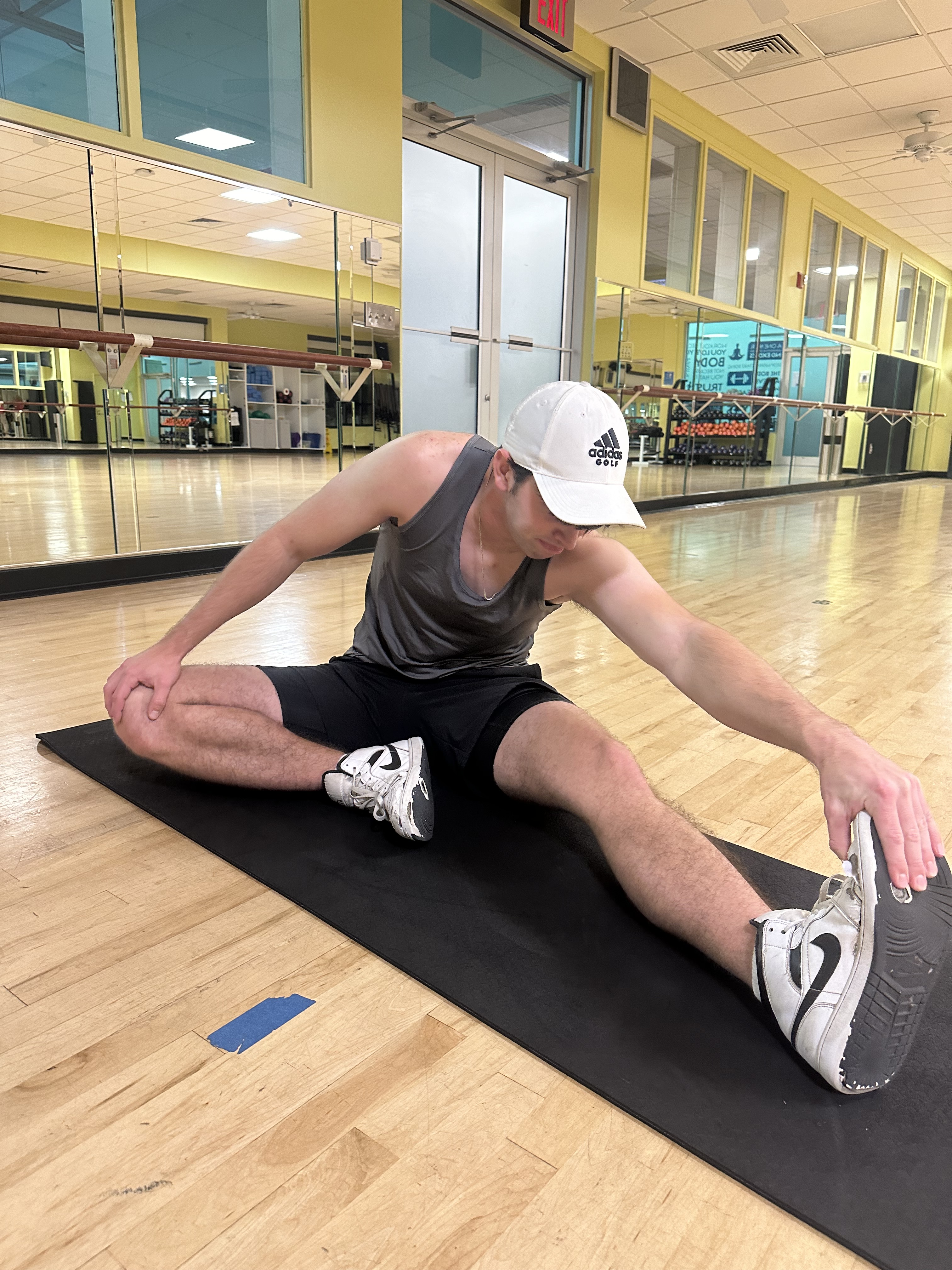 Athlete stretching to improve flexibility, with carbs supporting muscle growth and recovery